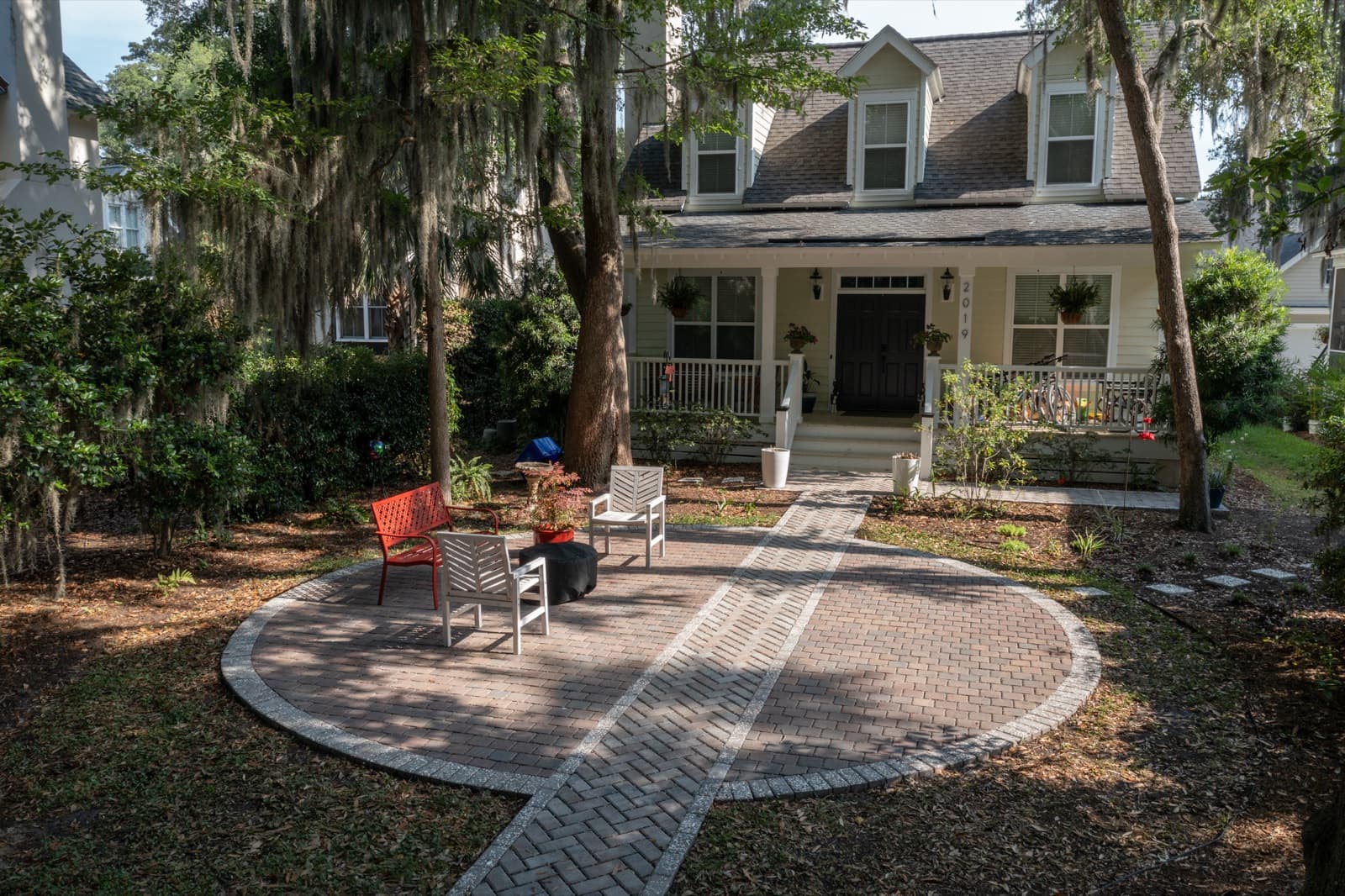 Wide view of the circular paver patio nestled into the wooded Port Royal yard