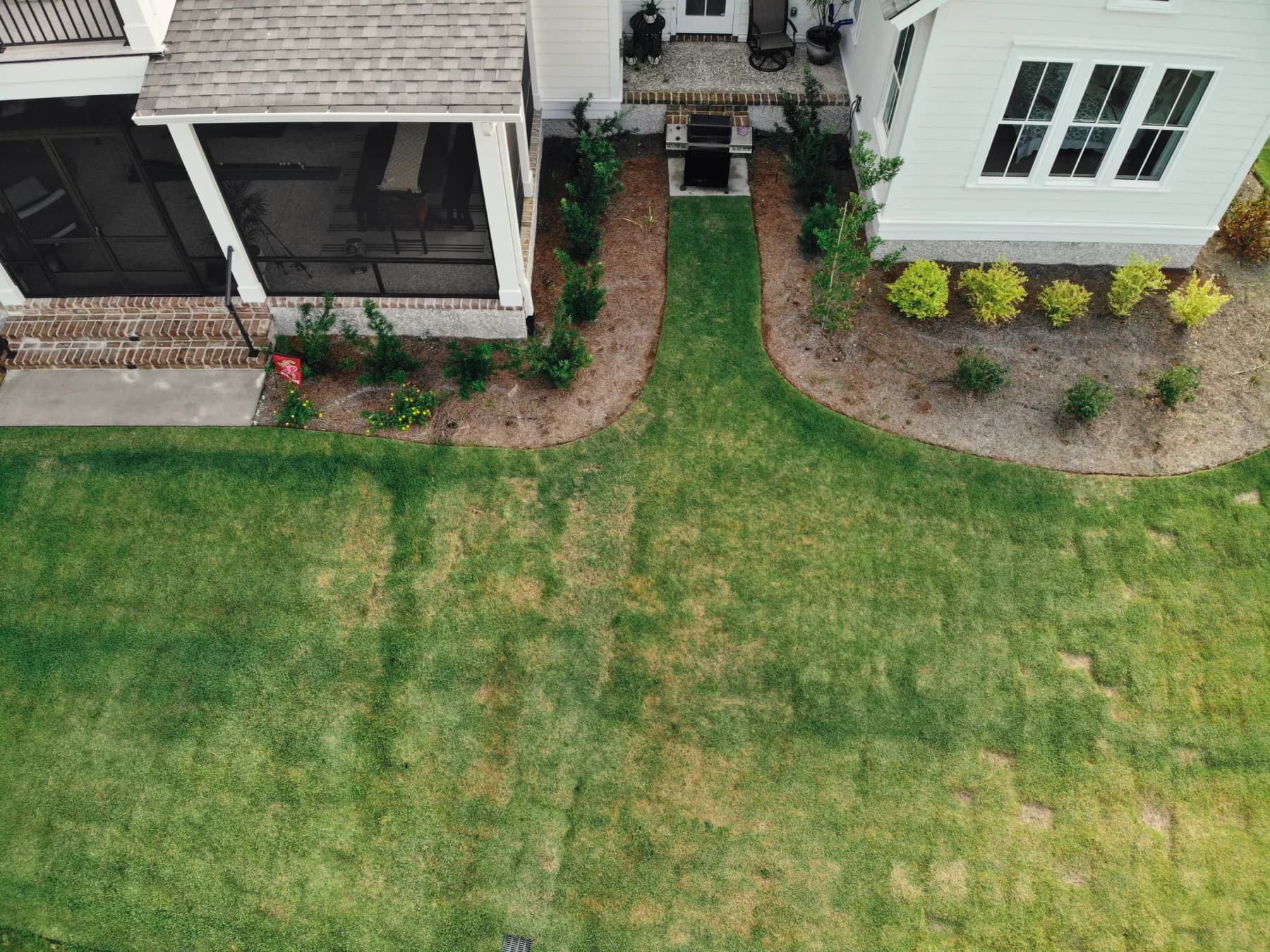 Before: the narrow planting beds and undersized grill area between the screened porch and rear of the home
