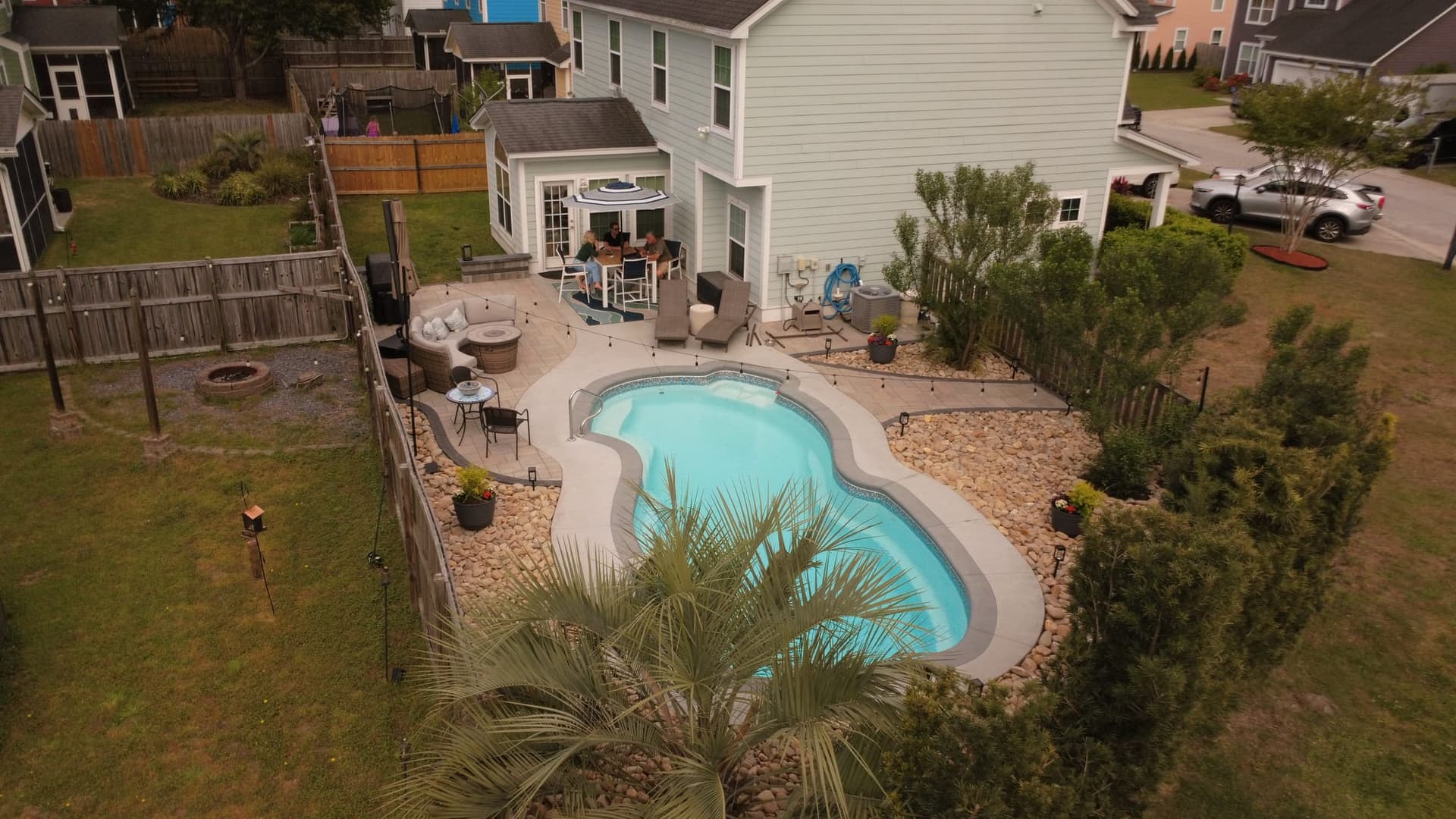 Aerial view of the finished pool deck expansion with lounge and dining areas and a low-maintenance rock garden