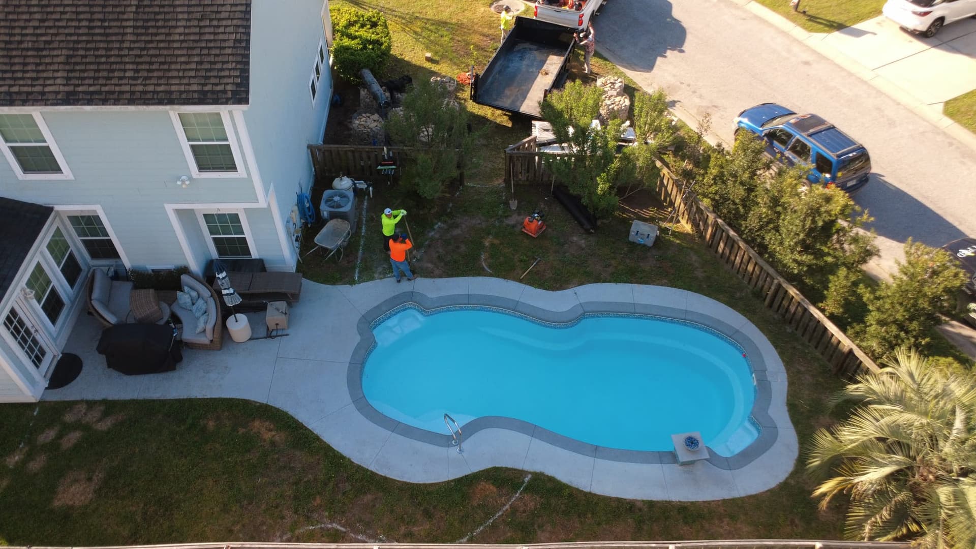 Before: aerial view of the cramped original pool deck bordered by patchy, high-maintenance lawn