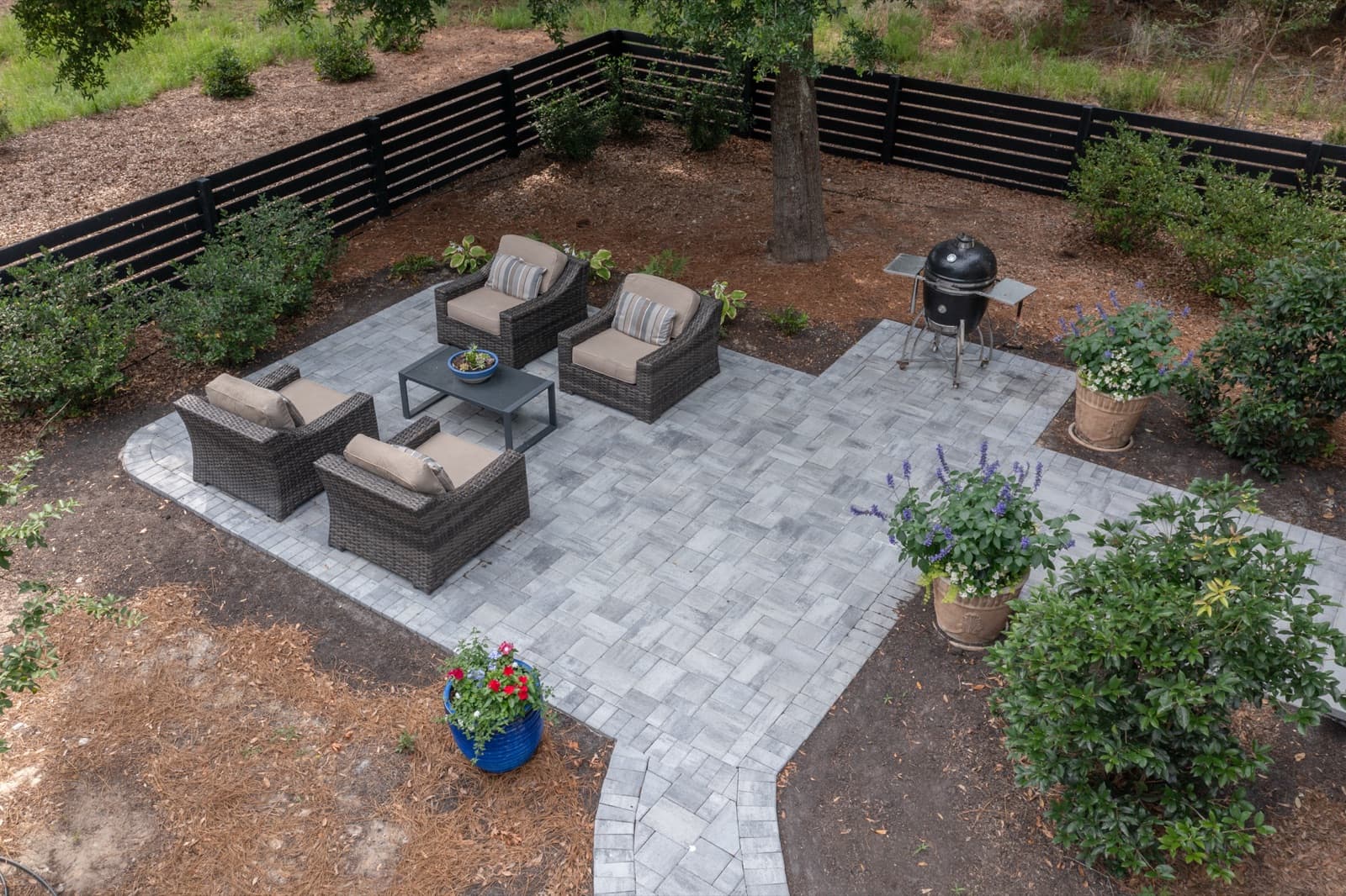 Modern paver patio with lounge furniture beside the white coastal home on Cat Island