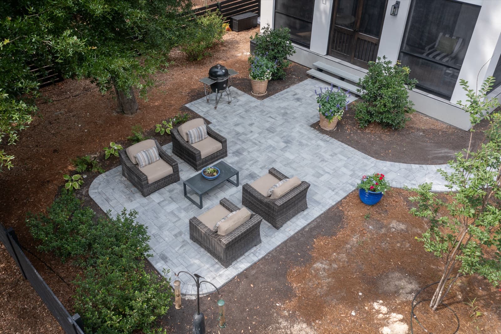 Paver path curving between privacy fencing and the home toward the rear patio
