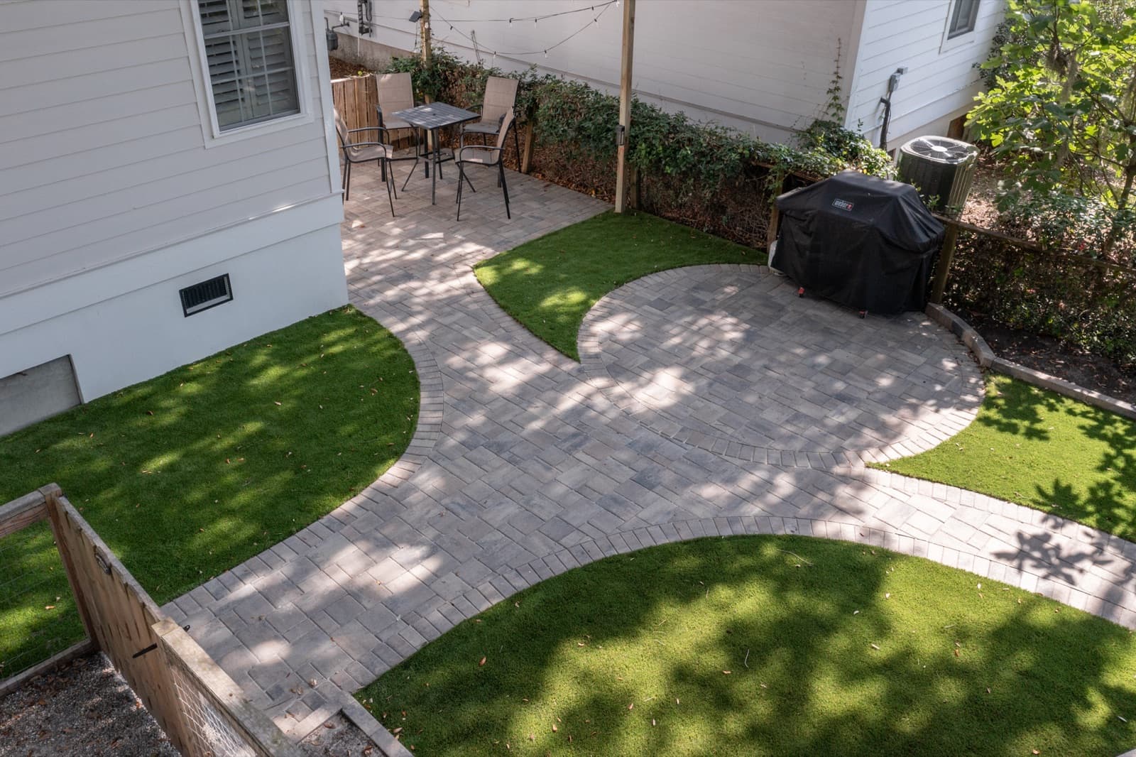Dining area on the paver patio near the house, connected by paver paths