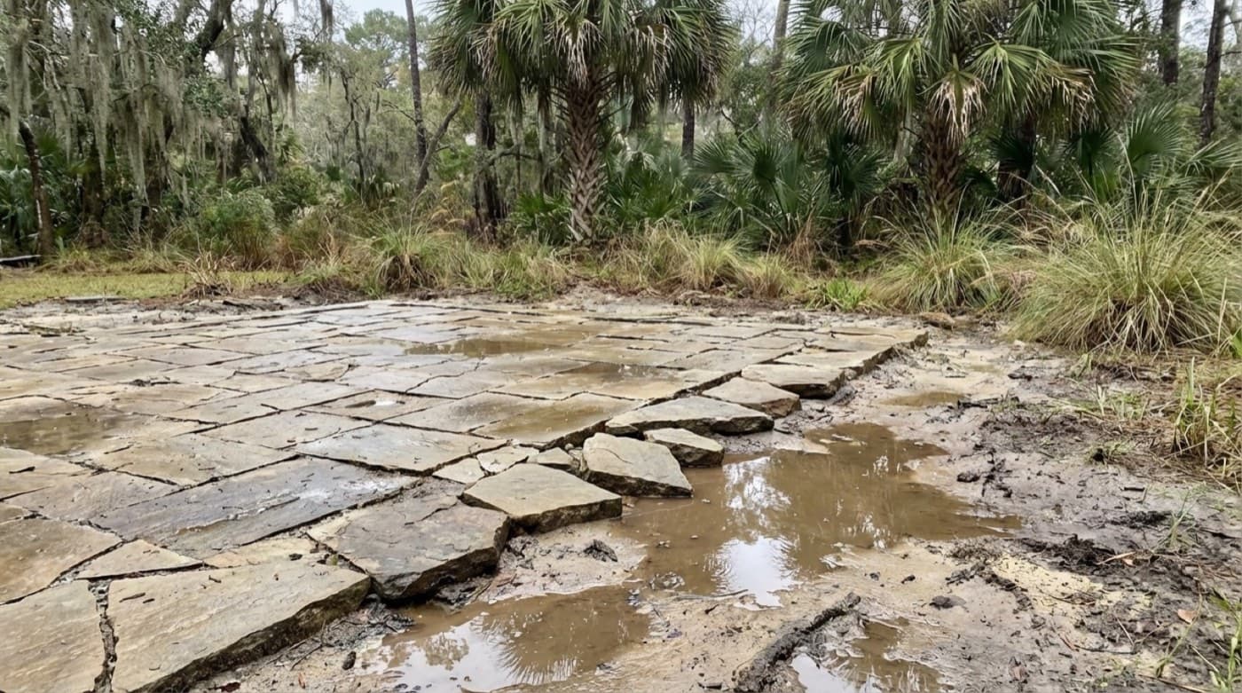 Uneven paver installation with pooling water and misaligned edges