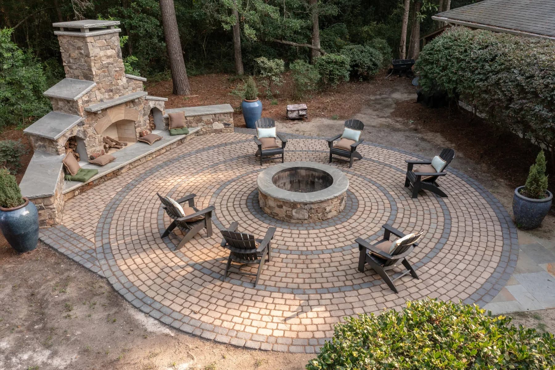 Chairs arranged around a circular stone fire pit on the finished James Island paver patio
