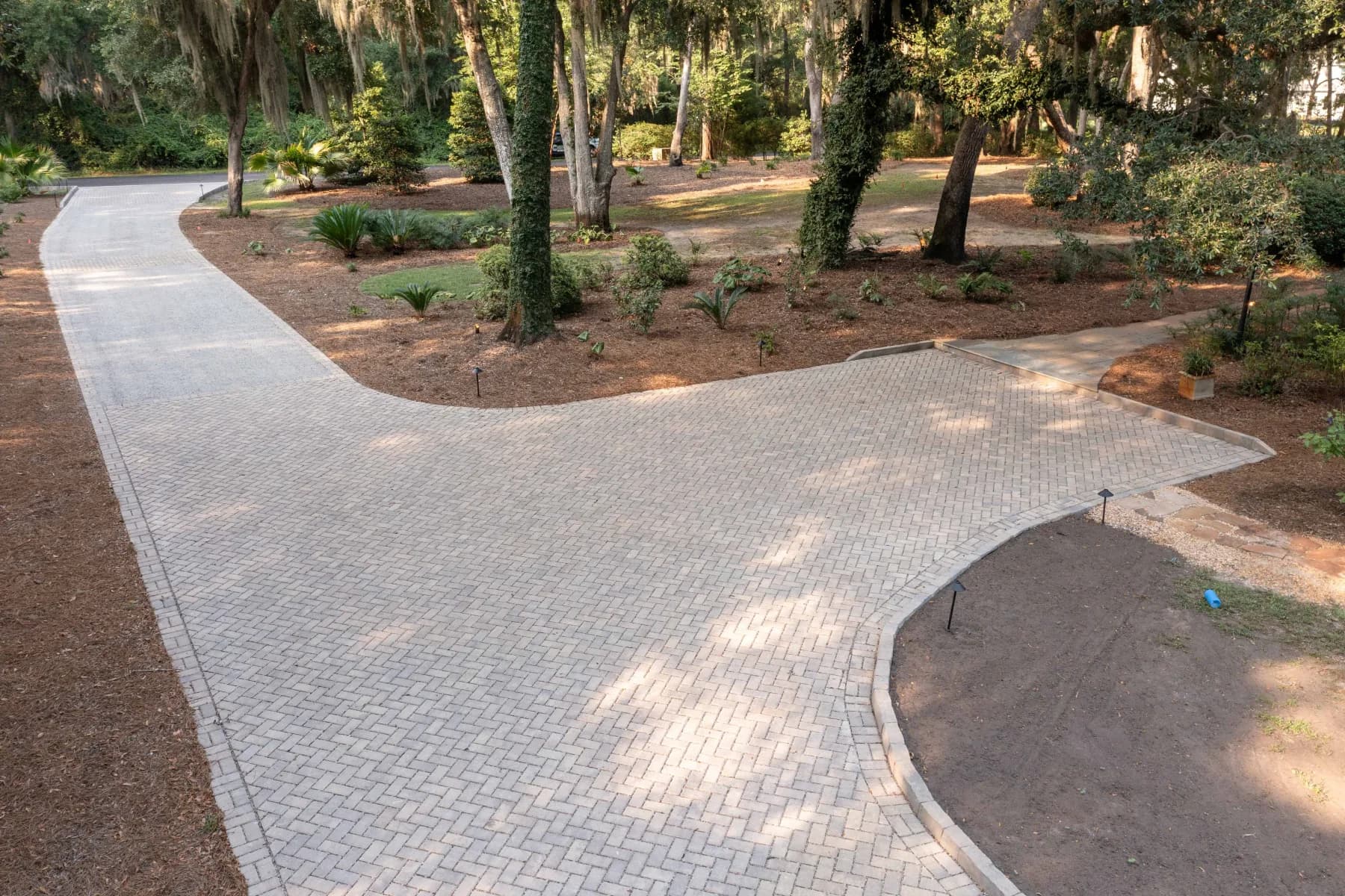 Wide aerial overview of the curved paver driveway, turnaround, and landscaped James Island property