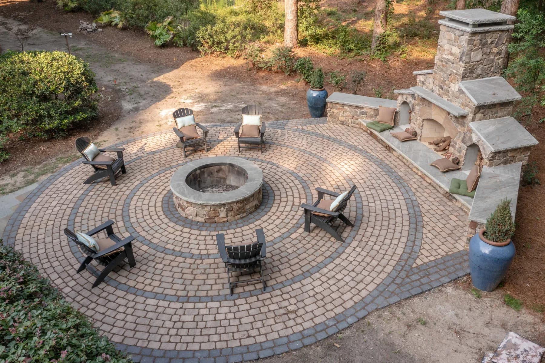Wide view of the fire-pit patio and natural-stone fireplace with extended built-in seating